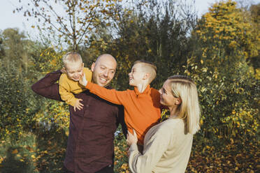 Smiling parents with children enjoying in autumn - AANF00433