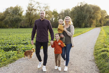 Glückliche Familie beim Spaziergang auf einem Wanderweg in der Natur - AANF00453