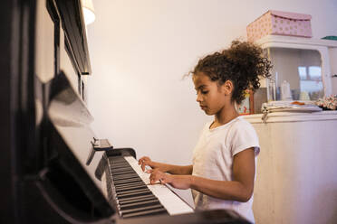 Mädchen übt zu Hause Klavier - MOEF04448