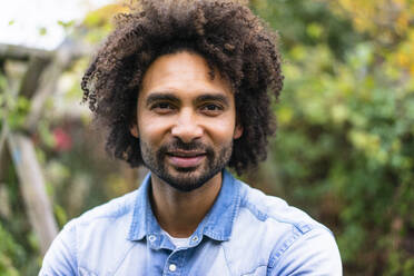 Lächelnder Mann mit Afro-Frisur und Bart - MOEF04450