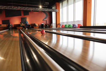 Frau spielt Bowling auf der Bahn - JCCMF08772