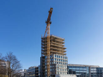 Deutschland, Bayern, München, Modernes Bürogebäude im Bau - MAMF02375