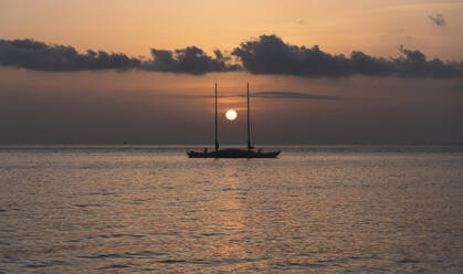 Spanien, Balearische Inseln, Sonnenuntergang über einem Segelboot auf dem Meer - JAQF01164