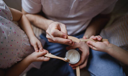 A top view of hands of unrecognizable father with two small children brushing teeth indoors at home, sustainable lifestyle concept. - HPIF05653