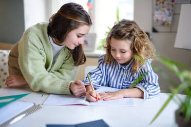 Portrait of sisters schoolgirls learning online indoors at home, coronavirus concept. - HPIF05723