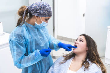 Zahnarzt untersucht die Zähne einer Frau in der Klinik - JAQF01181