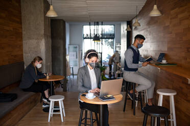 Junge Geschäftsleute mit Laptop, die in einem Café arbeiten, kleines Unternehmen, Coronavirus und neues Normalkonzept. - HPIF05752