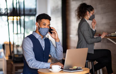 Junge Geschäftsleute mit Laptop, die in einem Café arbeiten, kleines Unternehmen, Coronavirus und neues Normalkonzept. - HPIF05754