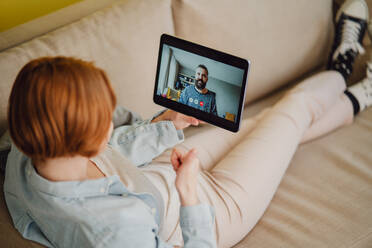 Junge Frau zu Hause macht einen Videoanruf mit Tablet, soziale Netzwerke Konzept. - HPIF05769