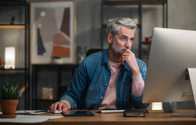 Ein reifer Mann Architekt arbeitet am Computer am Schreibtisch in einem Büro. - HPIF05804