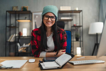 A happy female video editor works indoors in creative office studio, looking at camera. - HPIF05810