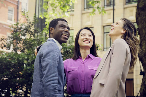 Cheerful businesswomen and businessman standing at park - PWF00572
