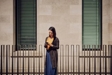 Businesswoman using mobile phone on sunny day - PWF00580