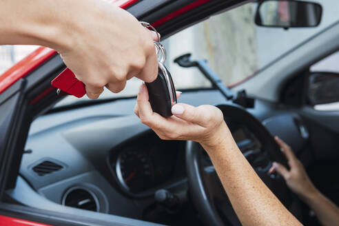 Salesman handling keys to customer - PNAF04853