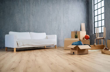 An empty living room with cardbord boxes ready to unpack, moving home concept. - HPIF05902