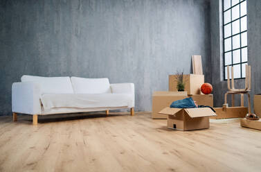Ein leeres Wohnzimmer mit Kartons zum Auspacken, ein Umzugskonzept. - HPIF05902