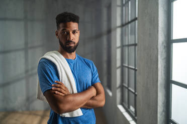 Young African American sportsman standing indoors at a gym, looking at camera, workout training concept. - HPIF05931