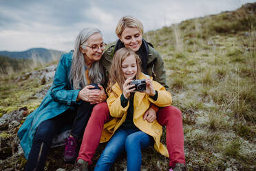 Ein kleines Mädchen mit Mutter und Großmutter, die auf dem Gipfel eines Berges ein Selfie machen. - HPIF06048