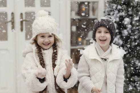 Glückliche Geschwister genießen den Schnee im Vorgarten - ONAF00370