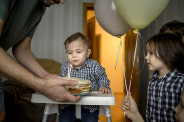 Vater mit Geburtstagstorte feiert den Geburtstag seines Sohnes zu Hause - ANAF00838