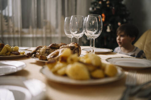 Junge mit Essen auf dem Esstisch zu Hause - ANAF00845