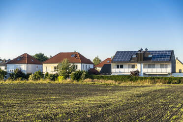 Haus mit Sonnenkollektoren auf dem Dach unter blauem Himmel - MAMF02413