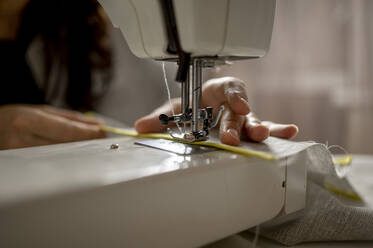 Woman using sewing machine at home - ANAF00850