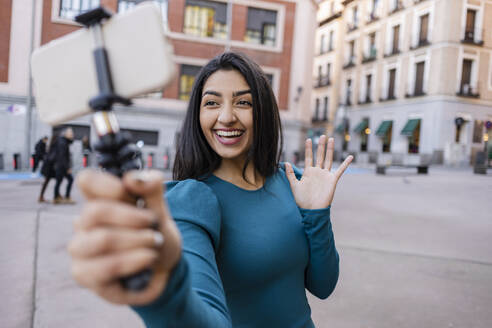 Glückliche Frau nimmt Selfie über Smartphone in der Stadt - JCCMF08961