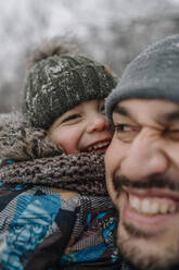 Sohn spielt mit Vater im Winter - ANAF00877