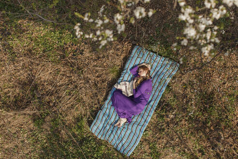 Young woman relaxing on mattress in garden - OSF01319