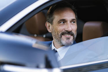 Smiling mature businessman sitting in car - OIPF02740