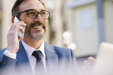 Smiling mature businessman talking on smart phone - OIPF02770
