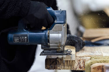 Handwerker mit Handsäge zum Schneiden von Holz in der Werkstatt - PGF01423