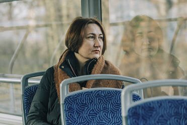 Nachdenkliche reife Frau in der Straßenbahn sitzend - VSNF00346