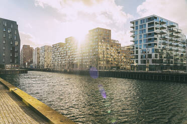 Denmark, Aarhus, Sun setting over modern apartments in Aarhus Docklands - TAMF03841