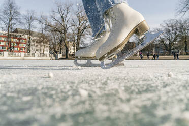 Mädchen beim Schlittschuhlaufen auf einer Eisbahn im Winter - OGF01281