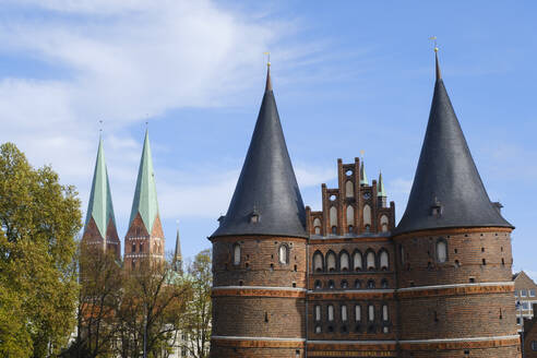 Germany, Schleswig-Holstein, Lubeck, Holstentor with spires of Marienkirche in background - WIF04686