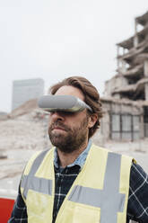 Älterer Arbeiter mit VR-Brille auf einer Baustelle - JOSEF15718