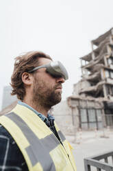 Arbeiter mit Virtual-Reality-Brille vor einer Baustelle - JOSEF15719
