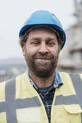 Smiling construction worker wearing hardhat - JOSEF15729