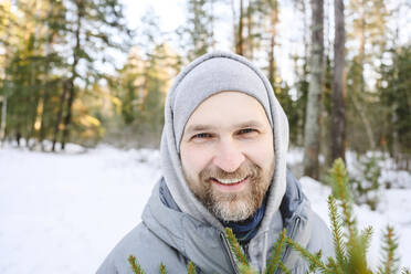 Glücklicher Mann mit Bart im Winterwald - EYAF02516