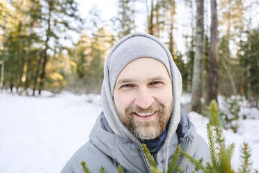 Happy man with beard in winter forest - EYAF02516