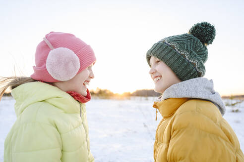 Fröhliches Mädchen genießt mit Bruder im Winter - EYAF02521