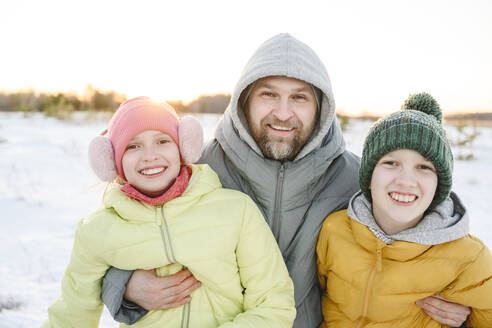 Happy father with son and daughter enjoying in winter vacation - EYAF02522