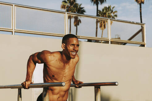 Happy mature man exercising on parallel bars - OIPF02843