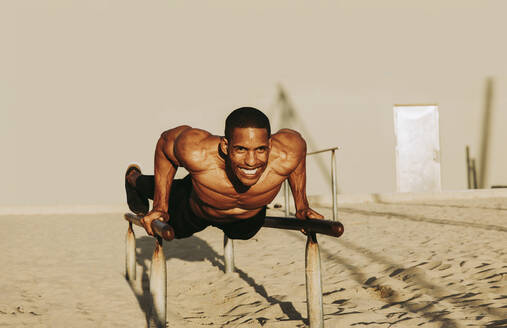 Happy mature sportsman exercising on parallel bars - OIPF02846