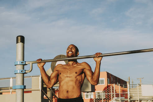 Active man exercising on gymnastics bar - OIPF02847