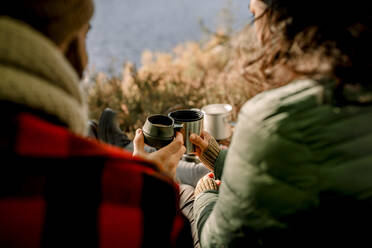 Friends toasting coffee during camping in forest - MASF34188