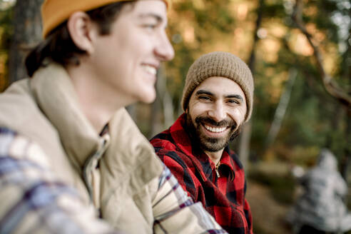 Porträt eines glücklichen Mannes mit einem jungen männlichen Freund beim Camping - MASF34223