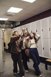 Happy Teenager-Mädchen, die Selfie mit weiblichen Freunden, während in der Schule Korridor genießen - MASF34316